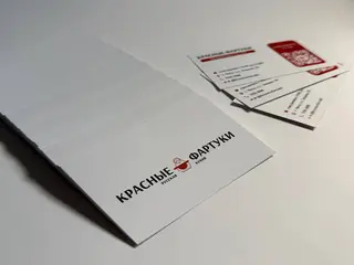 напечатанные корпоративные визитки на белом фоне с черными и красными элементами.
